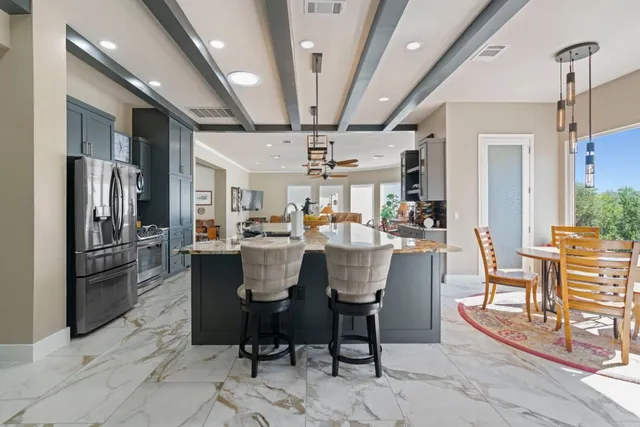 a dining room with stainless steel appliances kitchen island granite countertop furniture and a kitchen view