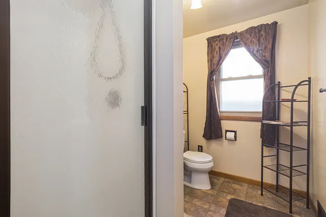 a bathroom with a toilet and a shower curtain