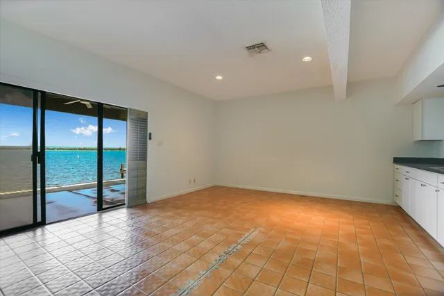 a view of an empty room with window and cabinet