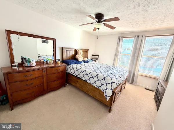 a bedroom with a bed dresser and a window