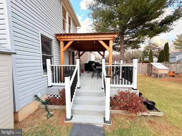 a view of a patio with table and chairs with wooden floor and fence