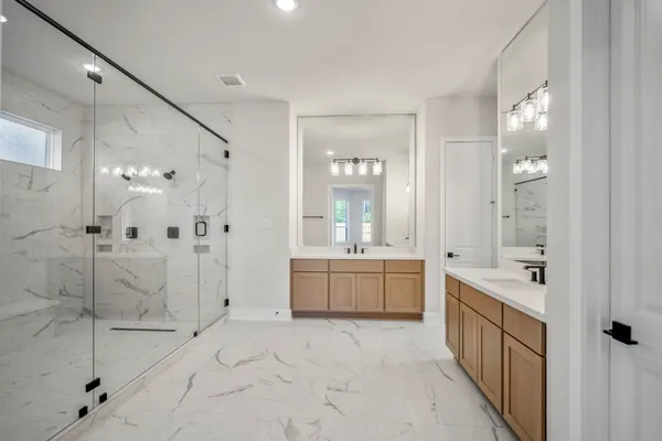 a bathroom with a granite countertop sink a toilet a mirror and shower