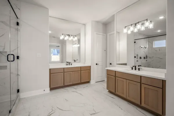 a bathroom with a double vanity sink mirror and shower
