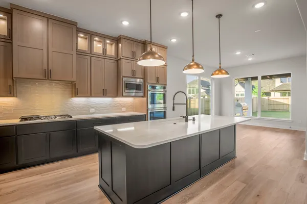 a kitchen with stainless steel appliances granite countertop a sink a stove and a wooden floors