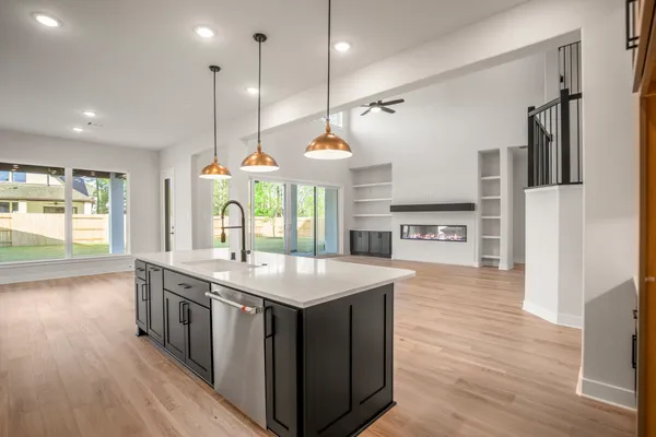 a kitchen with stainless steel appliances granite countertop wooden floors and sink
