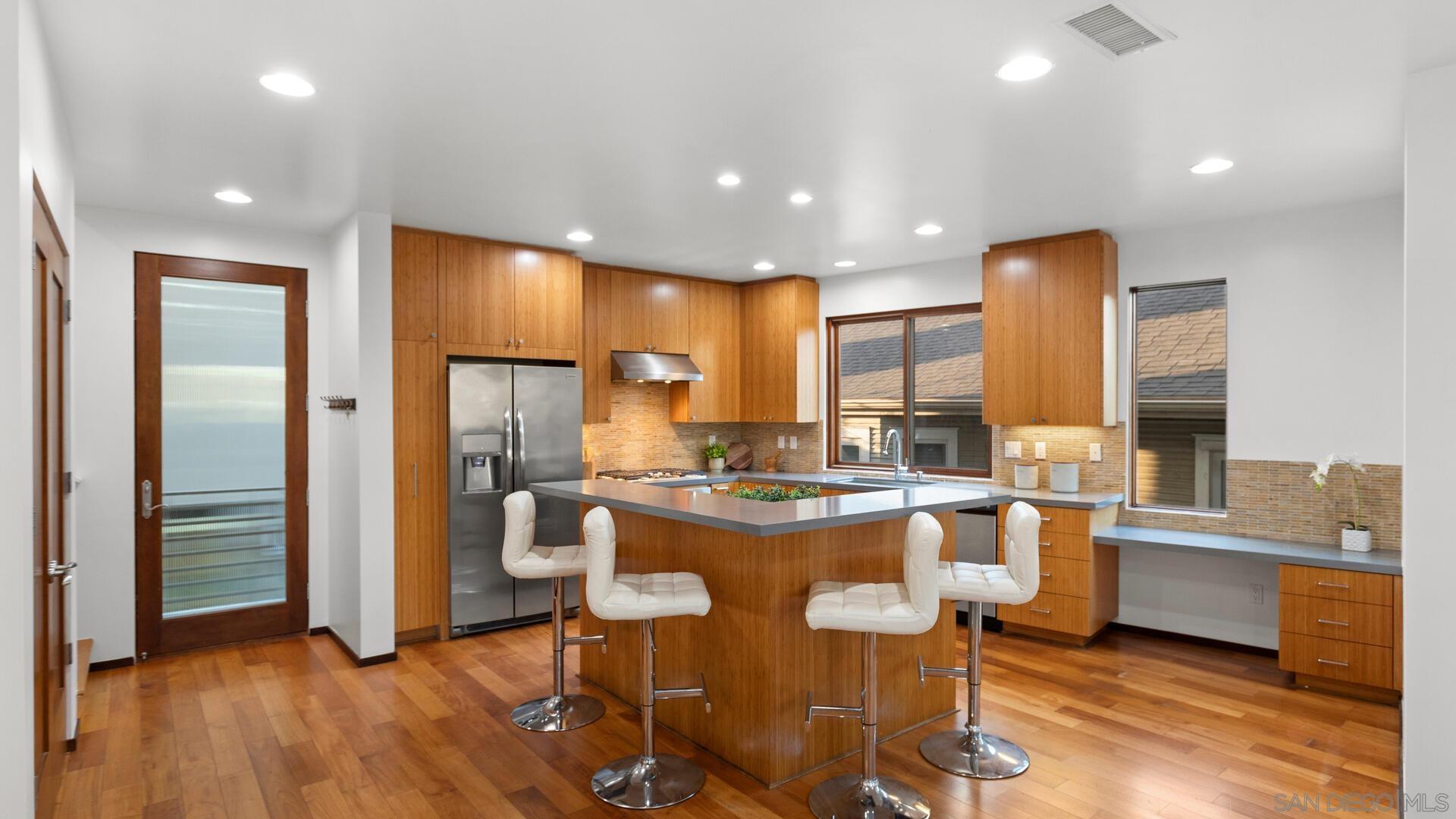 a kitchen with stainless steel appliances granite countertop refrigerator dining table and chairs