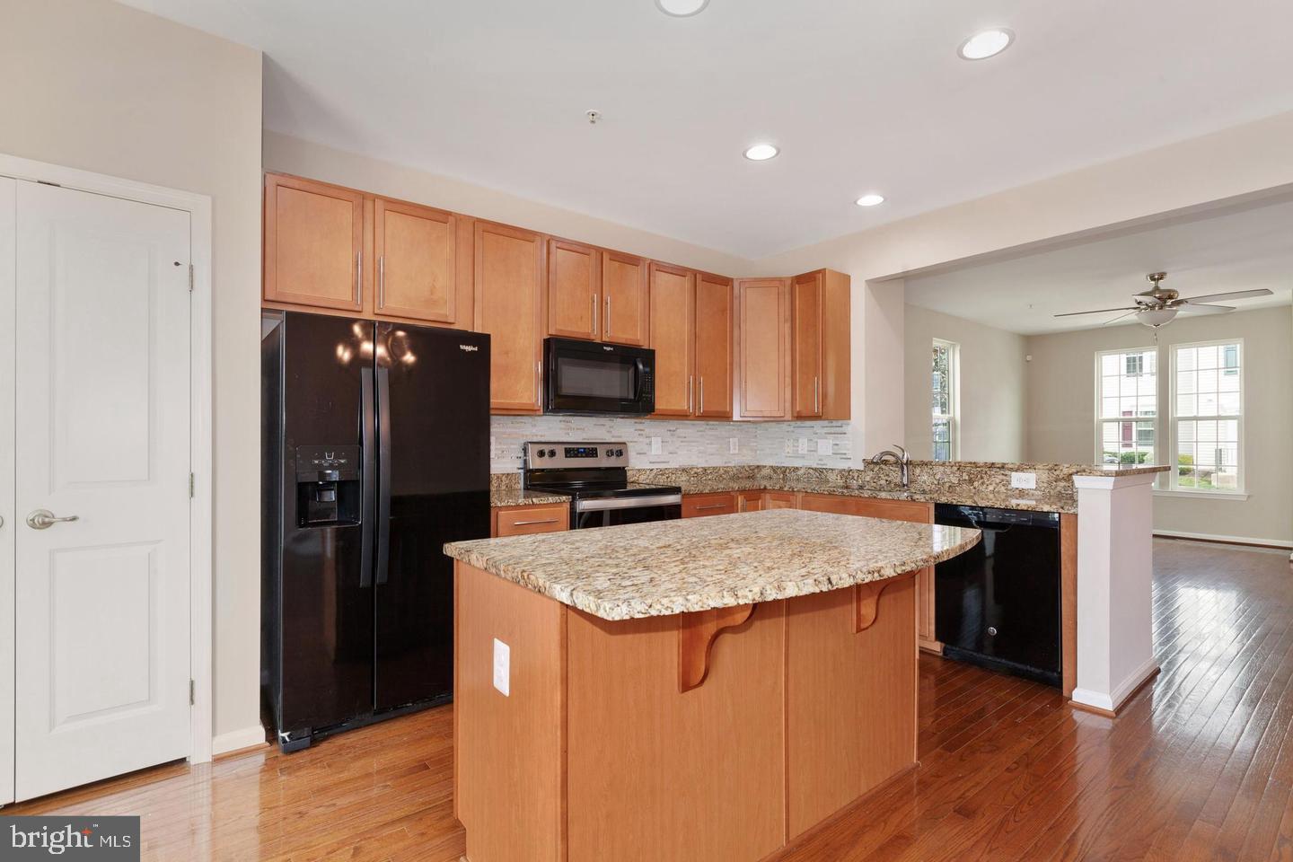 9418 Paragon Court Owings Mills, MD 21117 - Photo 12 of 42 a kitchen with a sink a stove a refrigerator a center island and a window