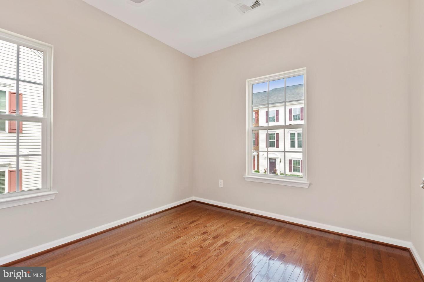 9418 Paragon Court Owings Mills, MD 21117 - Photo 19 of 42 an empty room with wooden floor and windows