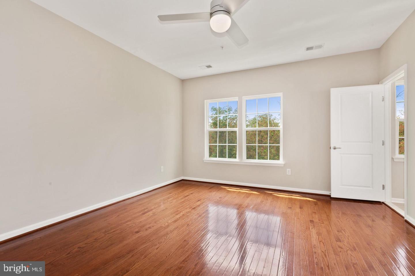 9418 Paragon Court Owings Mills, MD 21117 - Photo 21 of 42 an empty room with wooden floor and windows