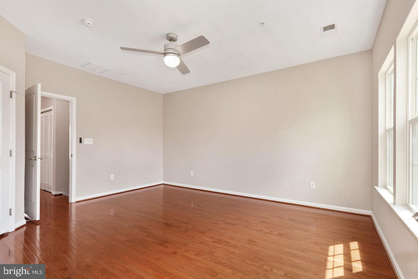 9418 Paragon Court Owings Mills, MD 21117 - Photo 24 of 42 an empty room with wooden floor fan and windows