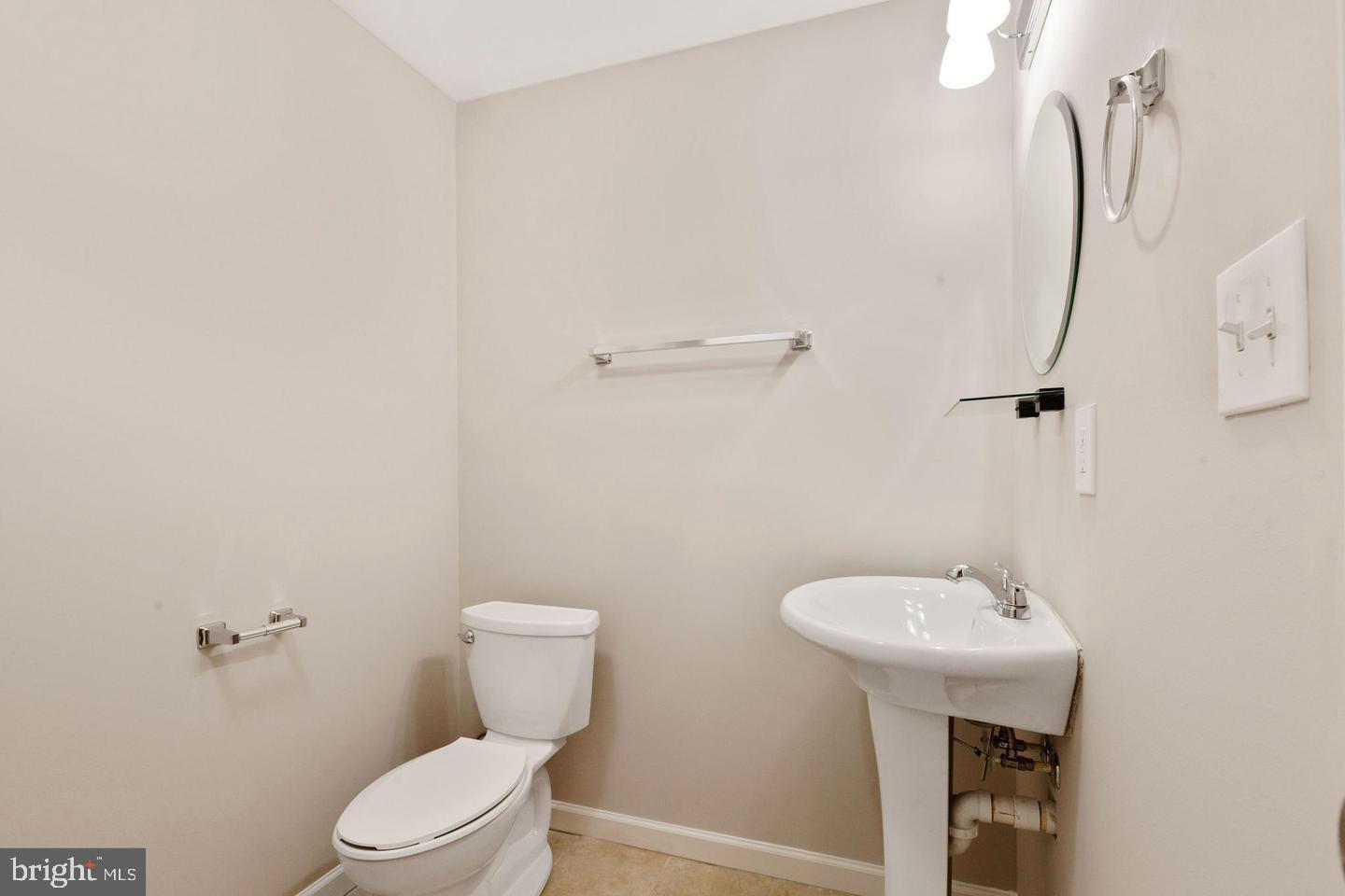 9418 Paragon Court Owings Mills, MD 21117 - Photo 37 of 42 a bathroom with a toilet sink and mirror