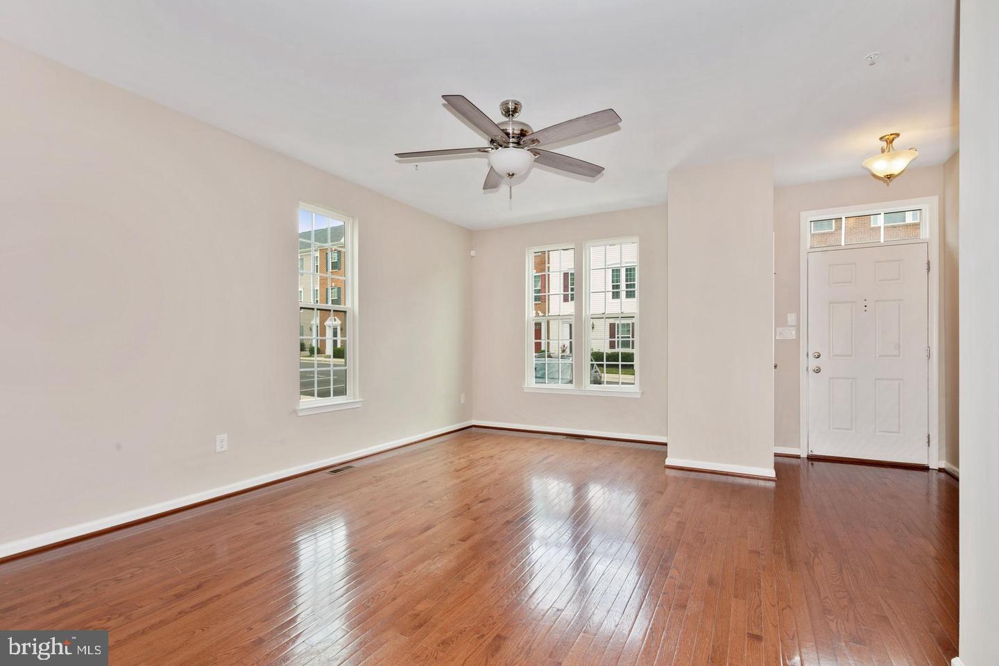 9418 Paragon Court Owings Mills, MD 21117 - Photo 6 of 42 an empty room with wooden floor a ceiling fan and windows