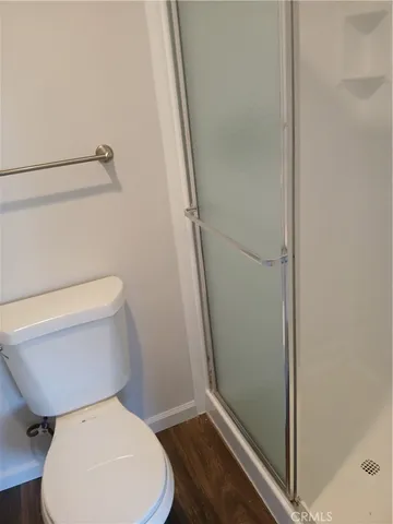 a white toilet sitting next to a shower
