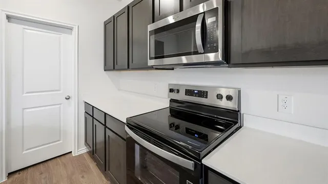 a view of kitchen with microwave oven and cabinets