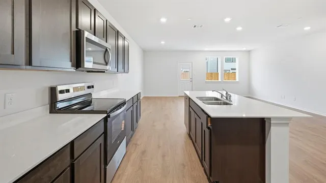 a view of kitchen with kitchen island microwave and stove