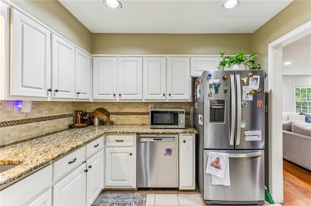 2592 Woodacres Road Northeast Atlanta, GA 30345 - Photo 15 of 27 a kitchen with granite countertop a sink stainless steel appliances and white cabinets