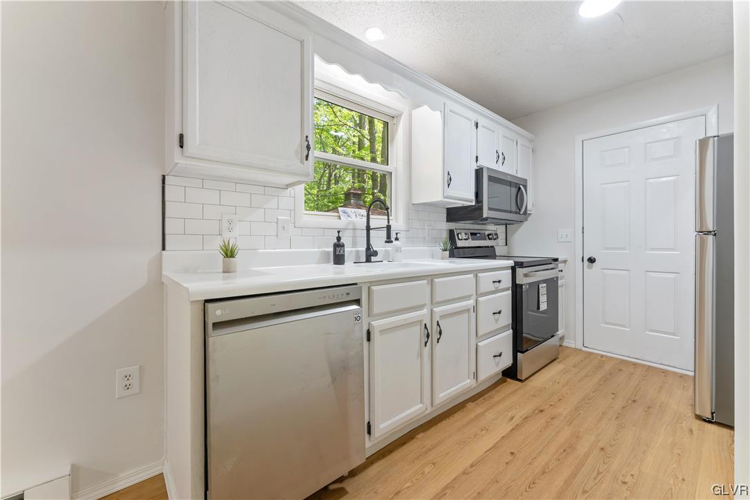 4121 Romeo Road Tobyhanna, PA 18466 - Photo 7 of 24 a kitchen with white cabinets sink and stainless steel appliances