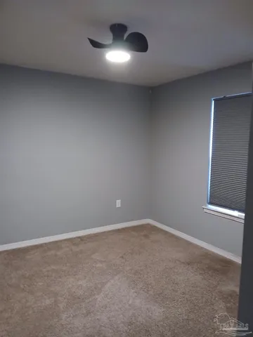 a view of an empty room with a ceiling fan