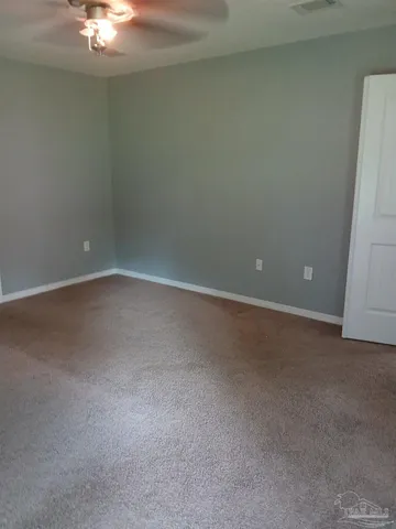 a view of an empty room with a chandelier fan