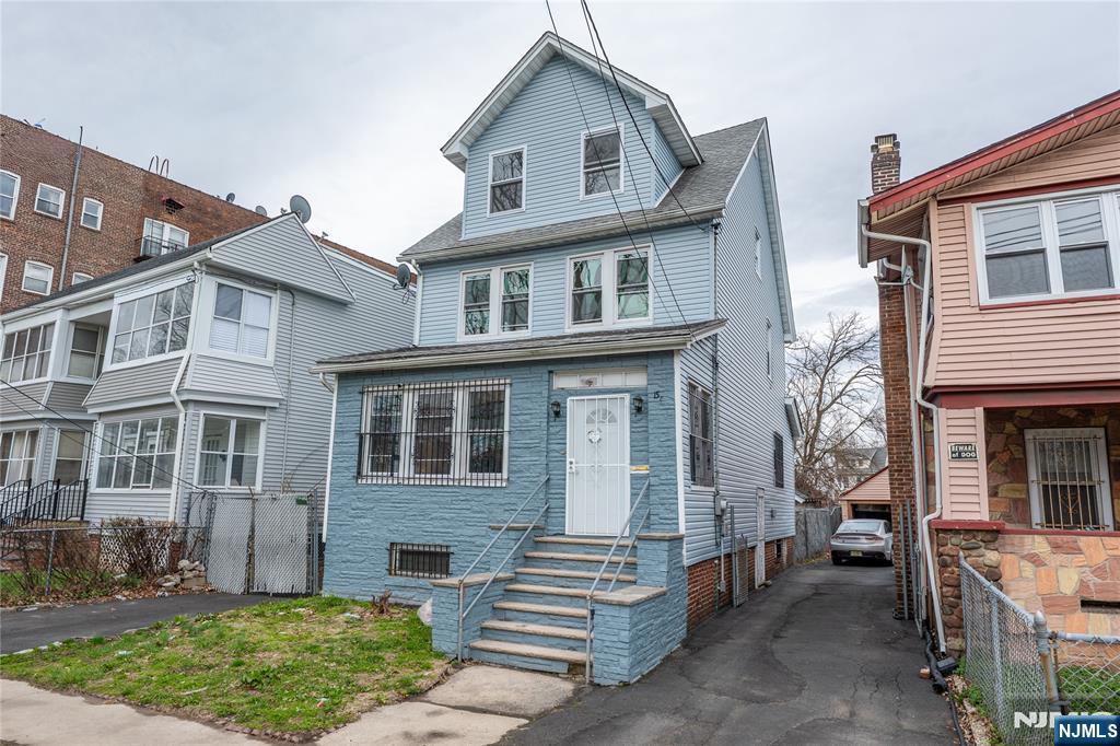 153 Augusta Street Irvington, NJ 07111 - Photo 1 of 26 a front view of a house with a garden