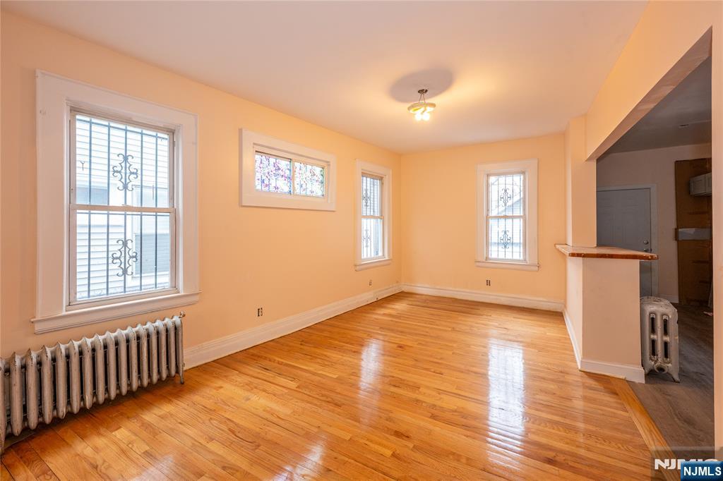 153 Augusta Street Irvington, NJ 07111 - Photo 11 of 26 a view of an empty room with a window and wooden floor