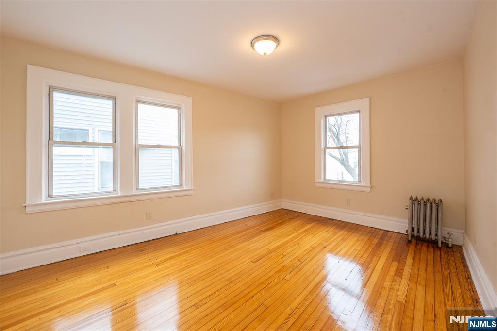 153 Augusta Street Irvington, NJ 07111 - Photo 14 of 26 a view of an empty room with wooden floor and a window