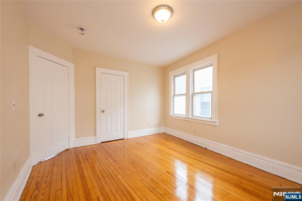153 Augusta Street Irvington, NJ 07111 - Photo 15 of 26 a view of empty room with wooden floor and fan