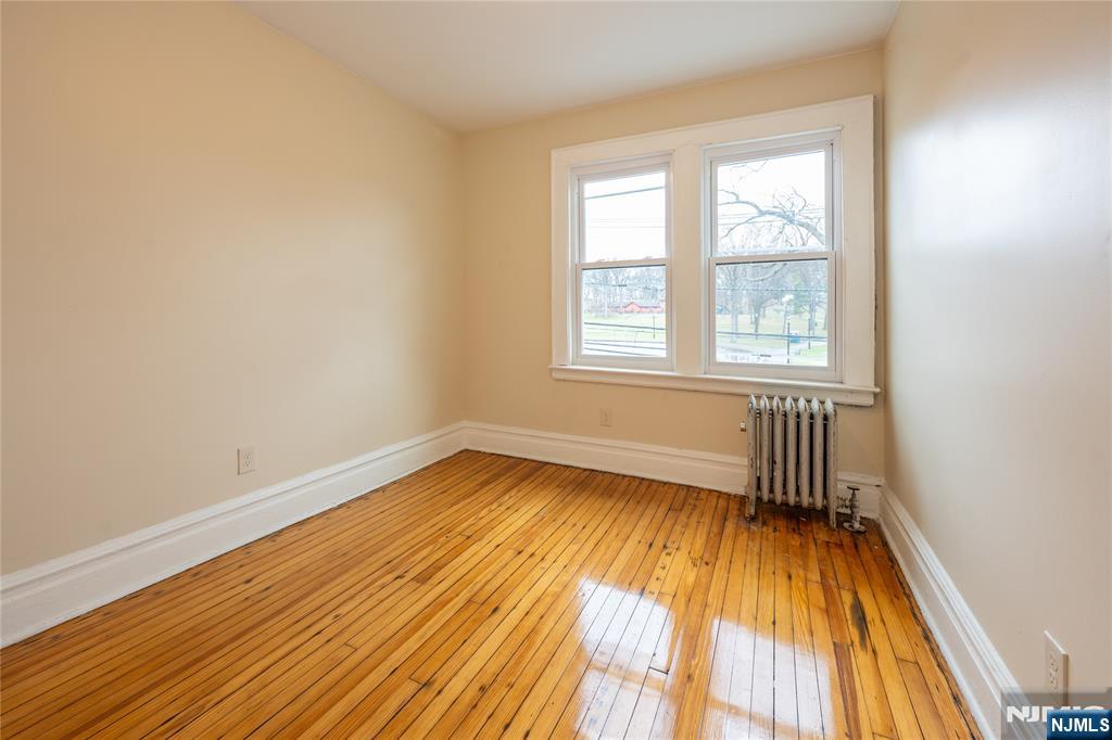 153 Augusta Street Irvington, NJ 07111 - Photo 16 of 26 an empty room with wooden floor and windows