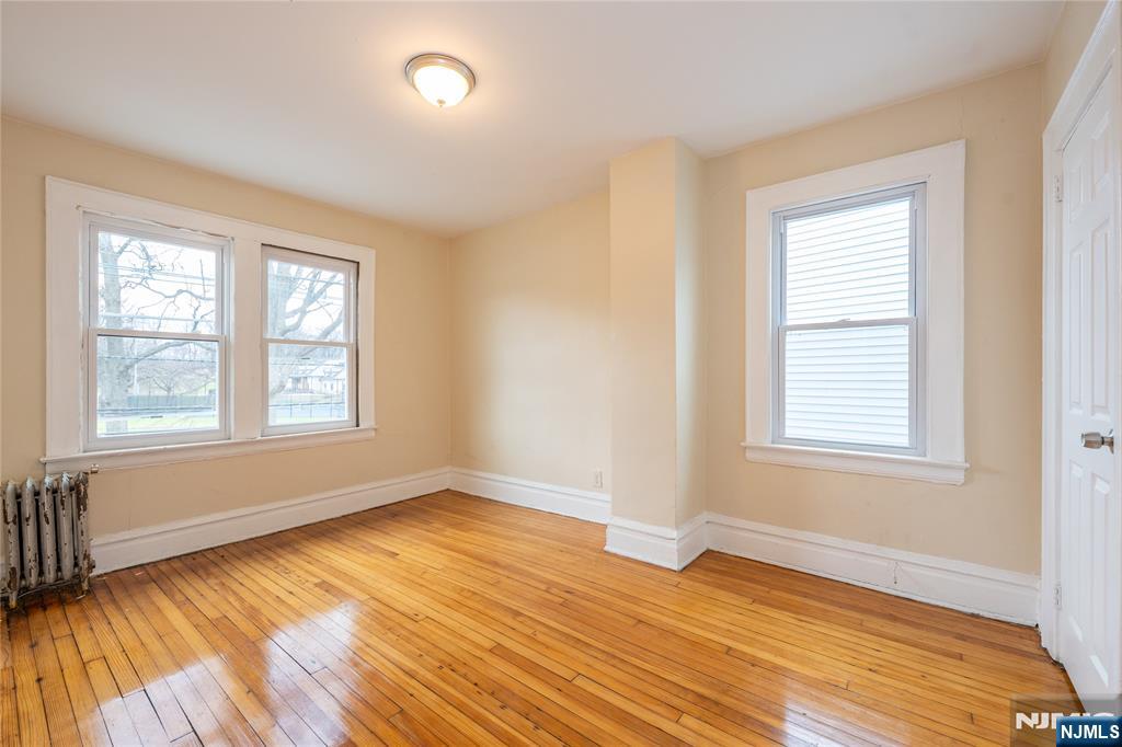 153 Augusta Street Irvington, NJ 07111 - Photo 18 of 26 a view of an empty room with wooden floor and a window