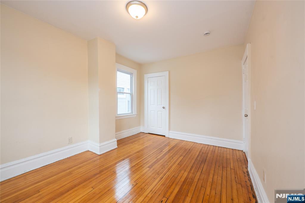 153 Augusta Street Irvington, NJ 07111 - Photo 19 of 26 a view of an empty room with wooden floor