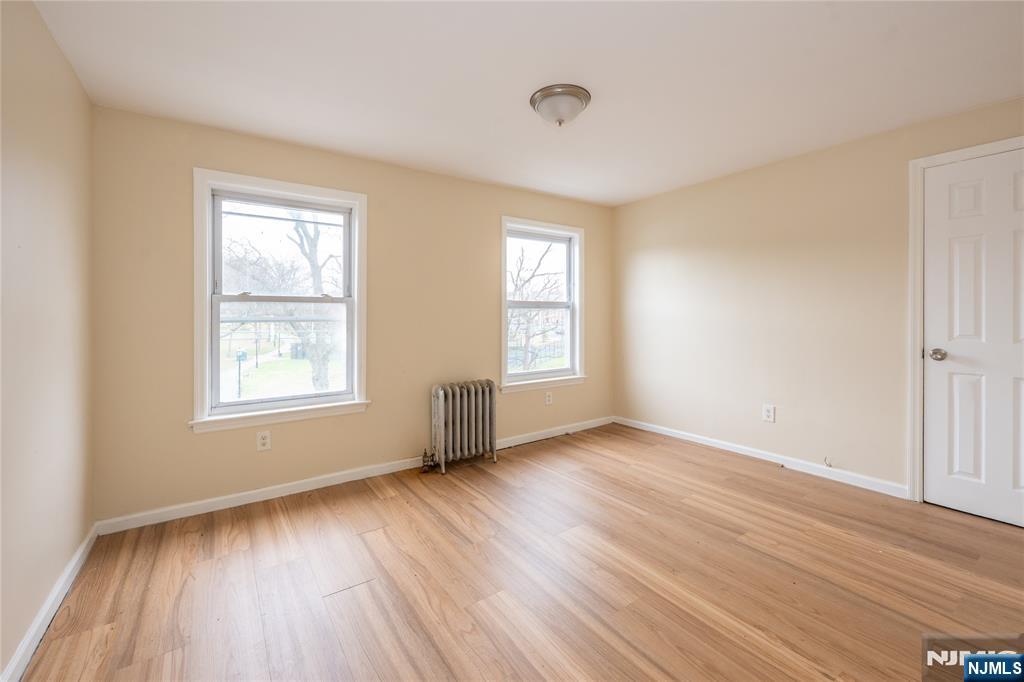 153 Augusta Street Irvington, NJ 07111 - Photo 21 of 26 a view of an empty room with wooden floor and a window