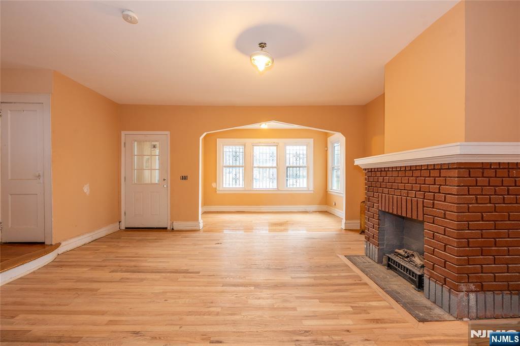 153 Augusta Street Irvington, NJ 07111 - Photo 5 of 26 a view of an empty room with a fireplace and a window