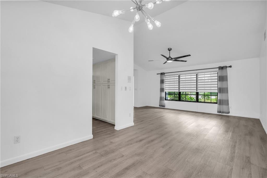 102 Muirfield Circle Naples, FL 34113 - Photo 11 of 43 an empty room with wooden floor and windows