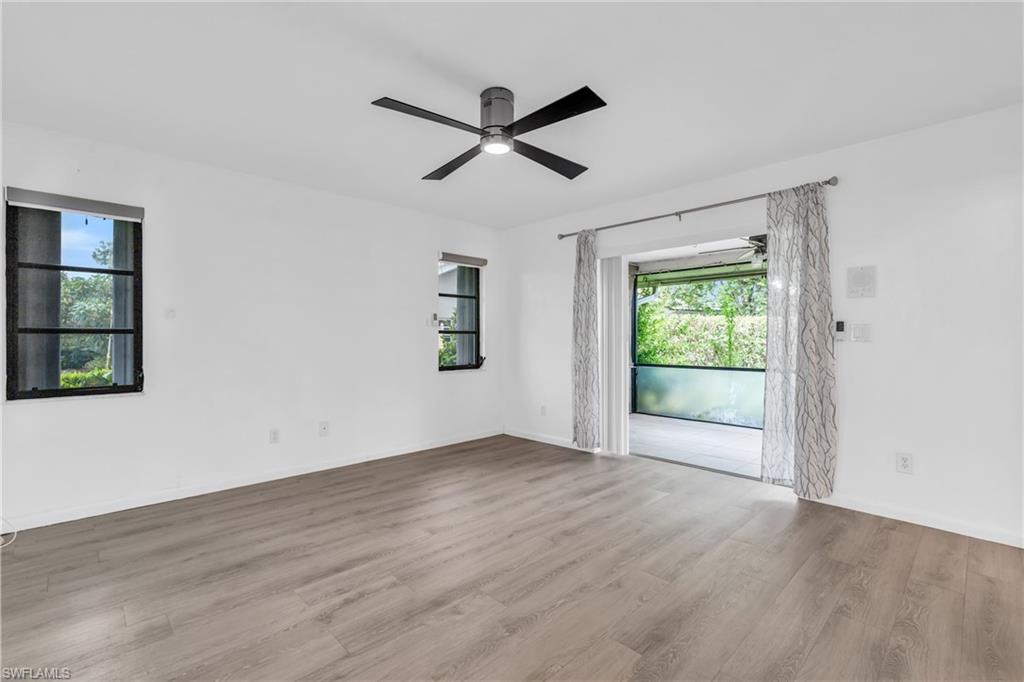102 Muirfield Circle Naples, FL 34113 - Photo 18 of 43 a view of empty room with wooden floor and fan