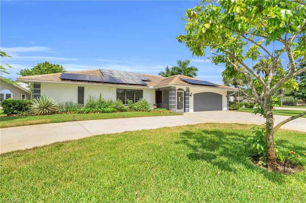 102 Muirfield Circle Naples, FL 34113 - Photo 2 of 43 a front view of a house with a garden