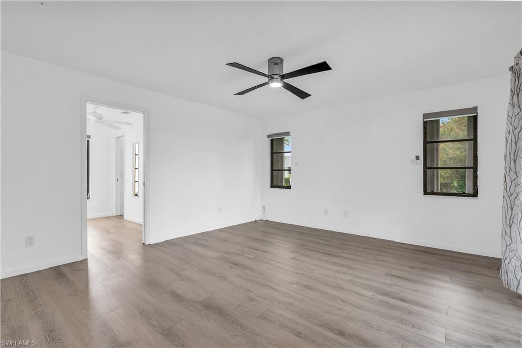 102 Muirfield Circle Naples, FL 34113 - Photo 21 of 43 an empty room with wooden floor and windows