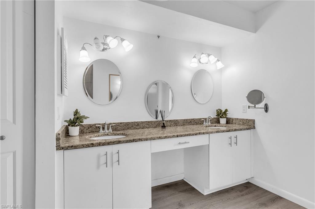 102 Muirfield Circle Naples, FL 34113 - Photo 22 of 43 a bathroom with a granite countertop double vanity sinks and a mirror