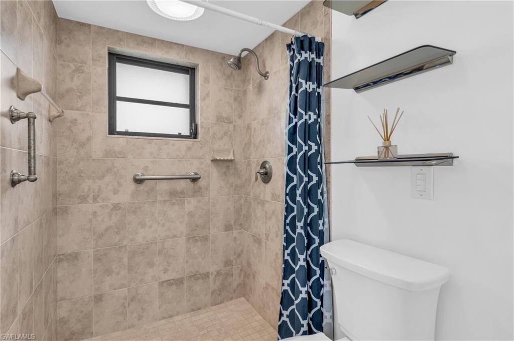 102 Muirfield Circle Naples, FL 34113 - Photo 23 of 43 a bathroom with a shower toilet and sink