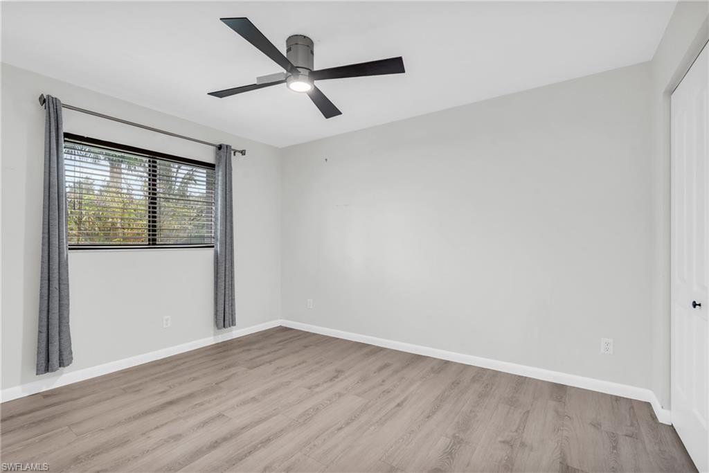 102 Muirfield Circle Naples, FL 34113 - Photo 26 of 43 an empty room with wooden floor and windows