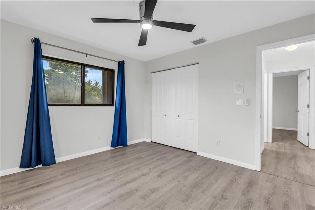 102 Muirfield Circle Naples, FL 34113 - Photo 30 of 43 an empty room with wooden floor and windows