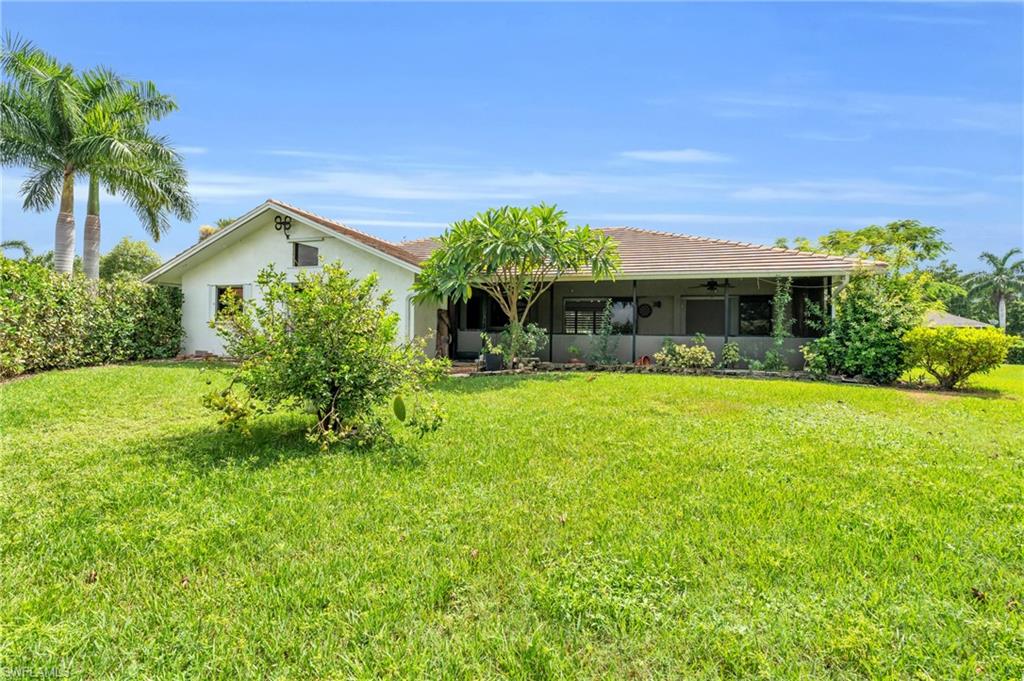 102 Muirfield Circle Naples, FL 34113 - Photo 3 of 43 a front view of house with yard and green space