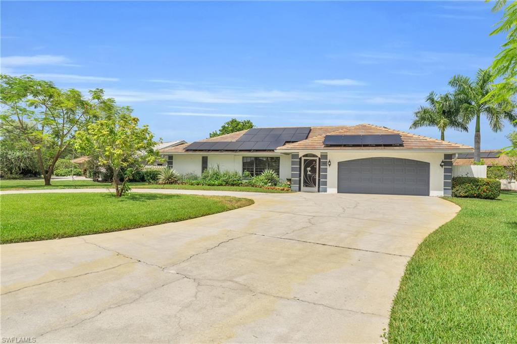 102 Muirfield Circle Naples, FL 34113 - Photo 33 of 43 a front view of a house with a yard
