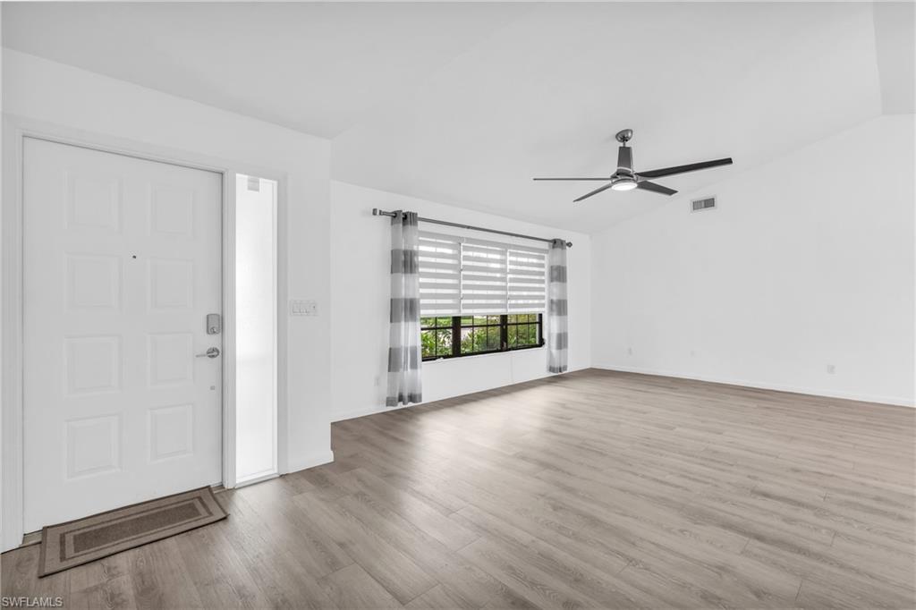 102 Muirfield Circle Naples, FL 34113 - Photo 8 of 43 a view of empty room with wooden floor and fan