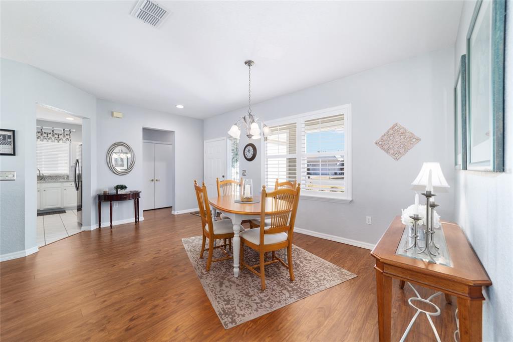 13146 Southeast 93rd Terrace Road Summerfield, FL 34491 - Photo 12 of 63 a dining room with furniture a chandelier and wooden floor