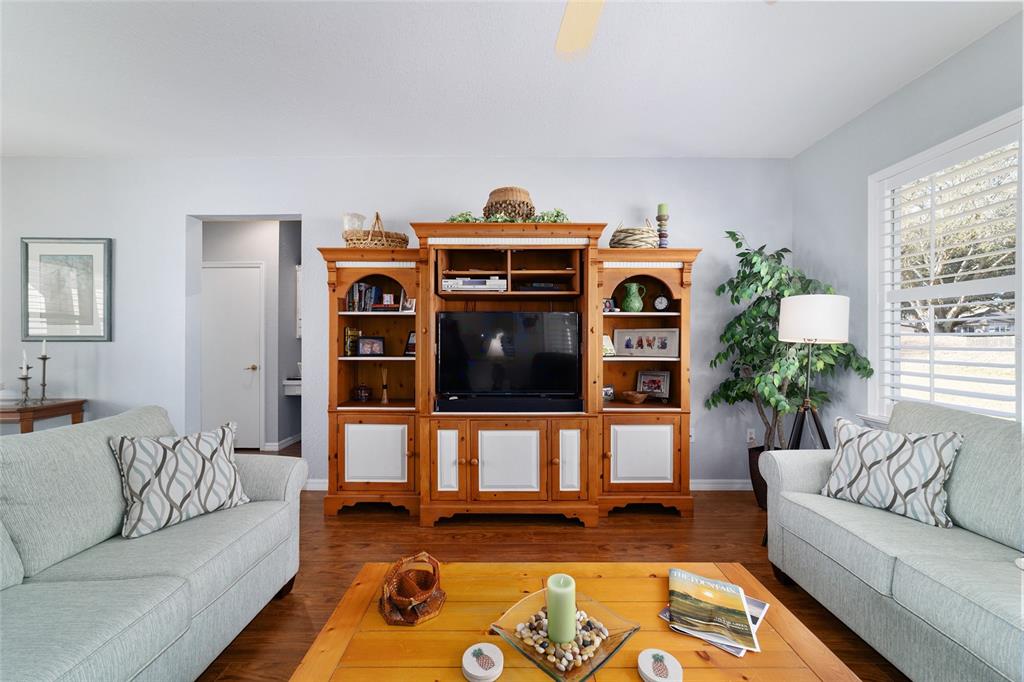 13146 Southeast 93rd Terrace Road Summerfield, FL 34491 - Photo 18 of 63 a living room with furniture and wooden floor