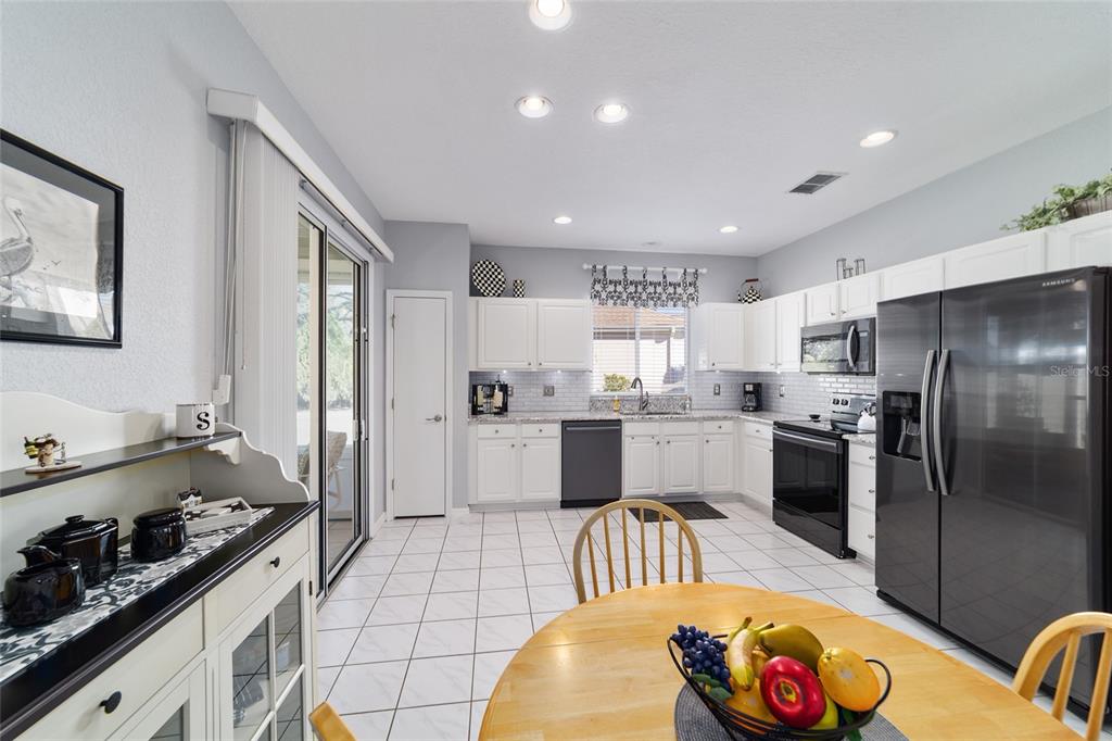 13146 Southeast 93rd Terrace Road Summerfield, FL 34491 - Photo 24 of 63 a kitchen with stainless steel appliances granite countertop a sink stove and refrigerator