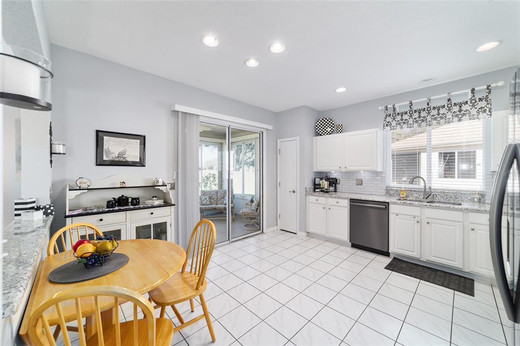13146 Southeast 93rd Terrace Road Summerfield, FL 34491 - Photo 25 of 63 a kitchen with stainless steel appliances granite countertop a stove a sink dishwasher and a refrigerator with wooden cabinets