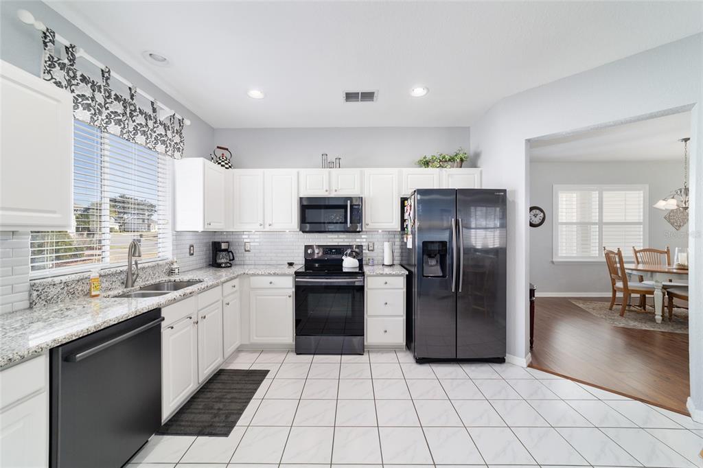 13146 Southeast 93rd Terrace Road Summerfield, FL 34491 - Photo 26 of 63 a kitchen with stainless steel appliances granite countertop a refrigerator and a sink