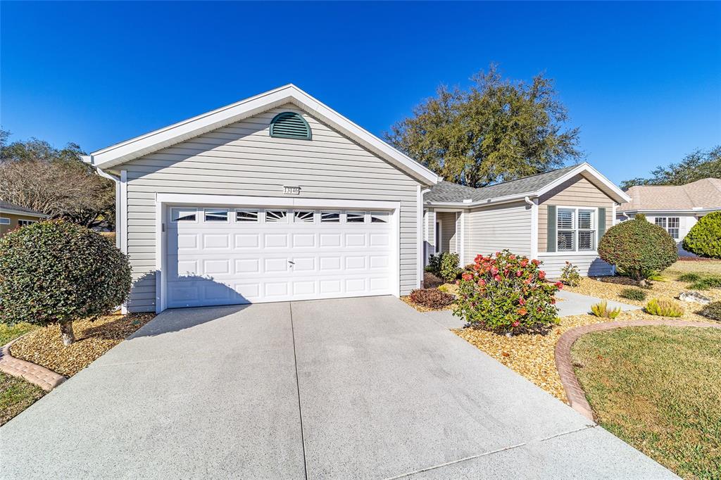 13146 Southeast 93rd Terrace Road Summerfield, FL 34491 - Photo 3 of 63 a front view of a house with a yard and garage