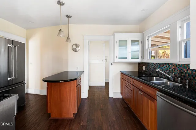 a kitchen with stainless steel appliances granite countertop a sink stove and wooden floor